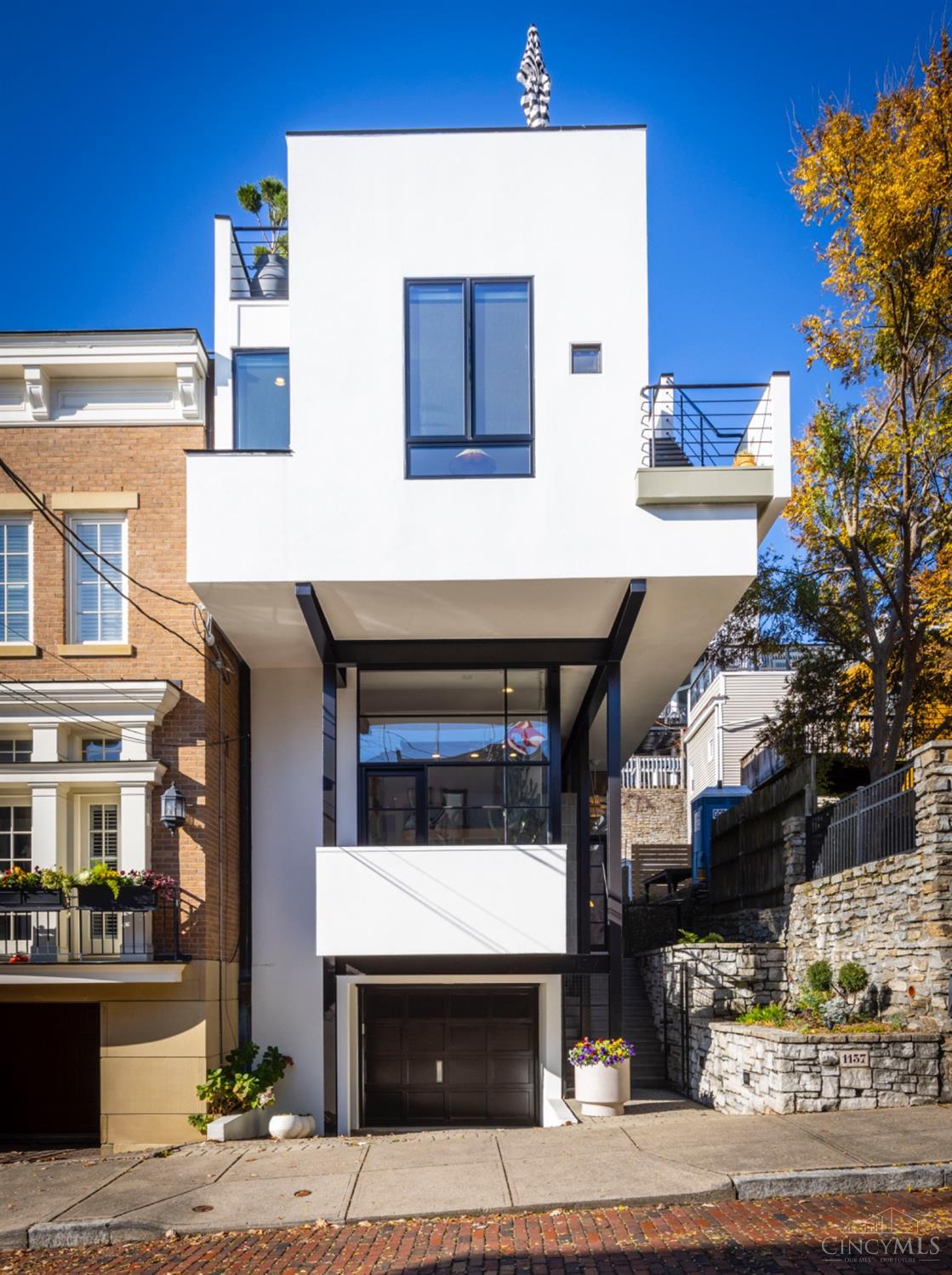 Award-winning John Senhauser masterpiece on one of Cincinnati's most exclusive streets. This 3-bedroom, 3.5-bath architectural gem boasts an open floor plan, 12 skylights, and floor-to-ceiling windows that flood the home with natural light. New Pella windows in bedrooms and kitchen ensuring modern efficiency and style. Enjoy stunning river views from the rooftop, which boasts new deck with stylish tiles. The custom kitchen is a chef's dream, showcasing Calacatta Viola marble, Brush Factory cabinetry, and Thermador appliances. Thoughtfully designed for modern living, the home offers tranquil outdoor retreats, including a private patio off the kitchen and guest bedroom. Exterior stairs are upgraded with durable TimberTech, blending function and style. Combining contemporary elegance with timeless design, this home epitomizes sophistication and unparalleled craftsmanship.