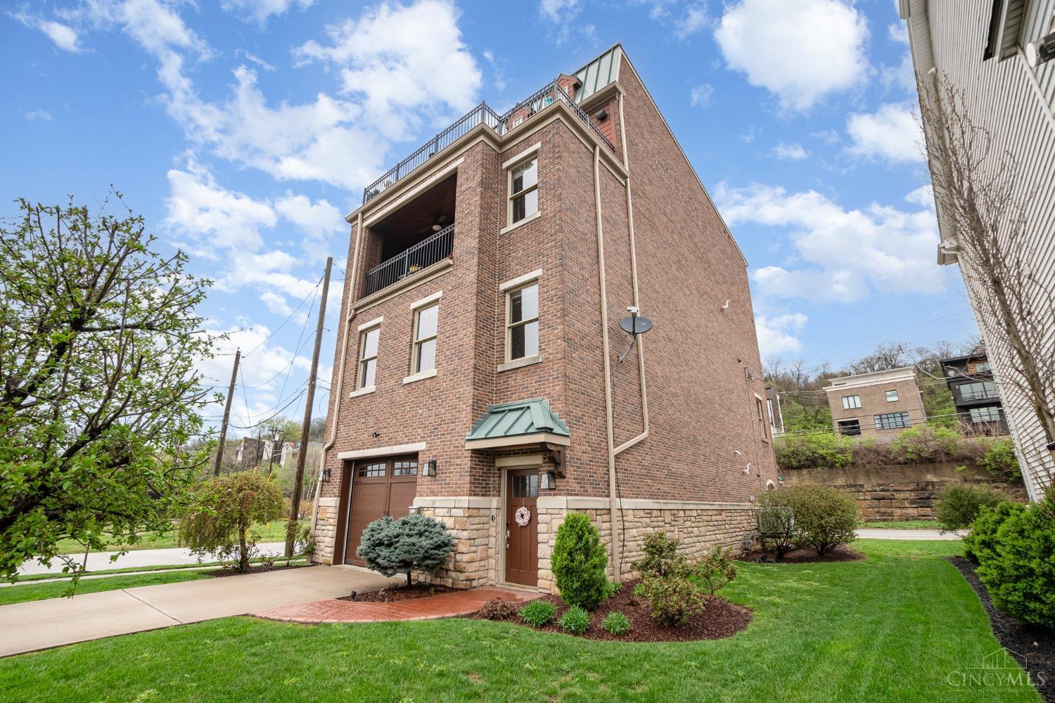 Embrace a lifestyle of ease in this impressive all-brick home, boasting breathtaking views of the river and city. An elevator conveniently connects the oversized tandem garage to all four levels! The spacious, light-filled rooms come with numerous updates.On the second floor, you'll find a generous kitchen that opens to the dining area and a great room featuring a fireplace, along with a private office. The third floor offers two guest rooms: one with an ensuite bathroom and the other with access to a covered porch, plus a hallway bathroom and laundry room to complete this level. The fantastic fourth floor showcases a divided primary bedroom with an updated bathroom and walk-in closet. It also includes a living area with a fireplace, a wet bar adorned with Rookwood tile, and a balcony that presents stunning views of the river and city, both day and night.