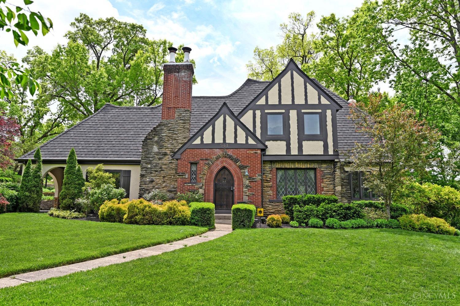 Multiple offers - highest and best due by 6PM 5/12. Seller reserves right to accept an offer at any time* Stunning 1920's Clifton Gaslight Tudor. Main living area features exposed beams and a gas fireplace, plus a formal dining room, and a naturally-lit den on first floor. The recently-renovated eat-in kitchen is expansive and features high-end cabinetry and appliances, including a convection/induction oven/range. The main living quarters feature three formal bedrooms, plus an additional flex room, offering plenty of space for everyone. The finished lower level includes a main living area and wet bar, plus laundry, and private office. The nearly half-acre lot is pristinely landscaped with a peaceful rear patio and fenced-in yard. Off-street parking pad for two cars, plus a driveway with an oversized, built-in garage that fits today's modern SUV or minivan. Ideal setting with mature privacy landscaping, while just steps from all that Ludlow Avenue has to offer!