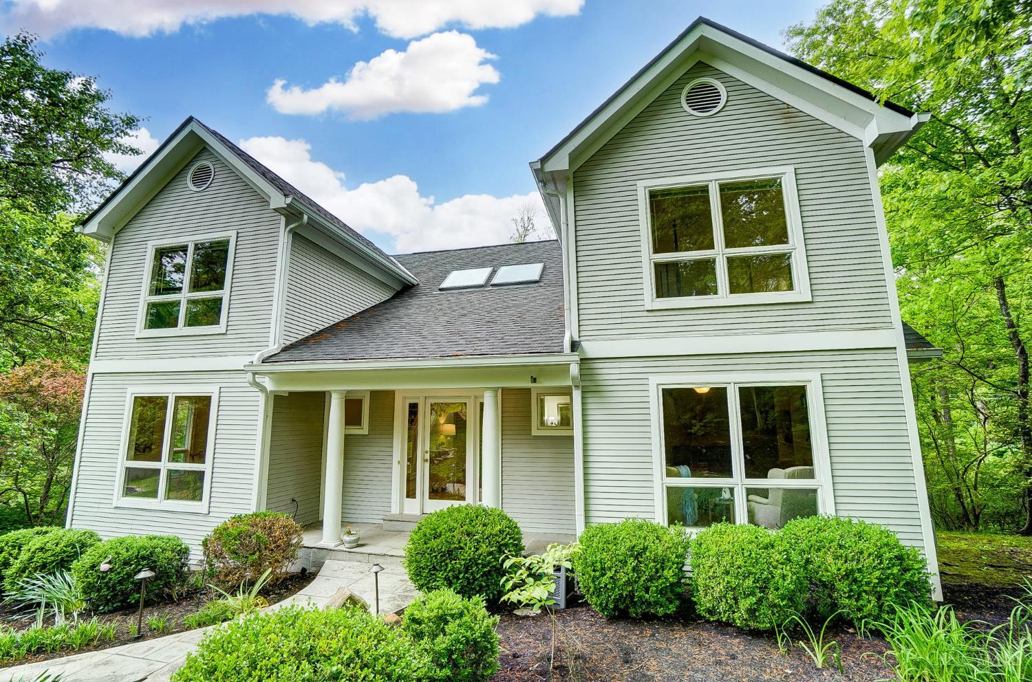 Tucked away in a serene wooded setting located just ten minutes from downtown, this beautifully updated home offers the perfect balance of modern comfort and natural charm. Flooded with natural light thanks to well-placed windows and a stunning skylight, this home feels warm and inviting from the moment you step inside. The first-floor primary suite is a true sanctuary, complete with an updated en-suite bath that has heated floors and a massive walk-in closet. The heart of the home is the updated eat-in kitchen, which seamlessly opens to a tiered deck, perfect for entertaining or simply enjoying the peace of the surrounding trees. The walk-out lower level expands your living space with access to a custom paver patio, ideal for relaxing evenings or weekend gatherings. Don't miss your chance to own this wooded retreat where every detail has been thoughtfully considered for comfort, style, and connection to nature. New roof in 2024, oversized garage, and newer deck.