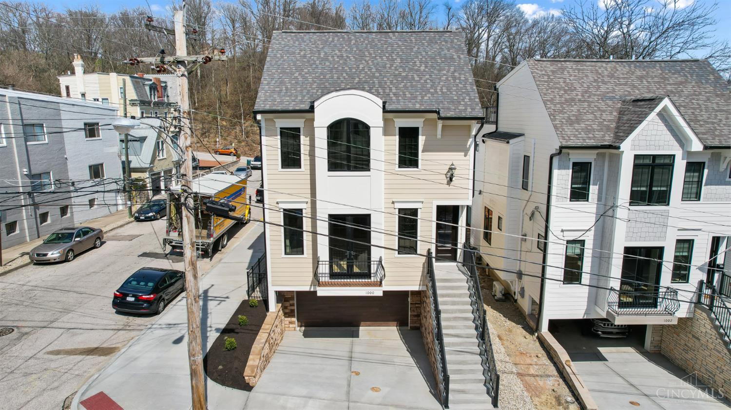 Completed in 2024 and One of the very last Unlimited Platinum 15-year Tax Abated LEED home. Est $25k/year in prop tax savings! Located in Mt Adams, this 4-fin-level custom home by Ashford Homes has an integral 2-car gar w/an internal elec car charger. Enjoy 10' 1st floor ceilings with an open floorplan design. The designer kitchen has top-shelf Amish handcrafted & hand painted Grabill cabinets, capped off w/high-end Thermadore appl. Covered deck leading to the backyard. Enjoy the gathering room w/a 60''modern linear gas FP. Put your plants out on the adj South facing front balcony to enhance your curb appeal. The 2nd flr offers 3 spacious bdrms w/custom closet organizers. The primary bdrm has a modern FP & a designer influenced bath with built-in cabinets &  wainscoting ceramic tile walls. The adjoining laundry room incl an LG Studio W&D. The top floor offers a lg rec rm. wetbar/beverage cooler. French sliding full height doors that lead you to the rooftop deck w/gas line.