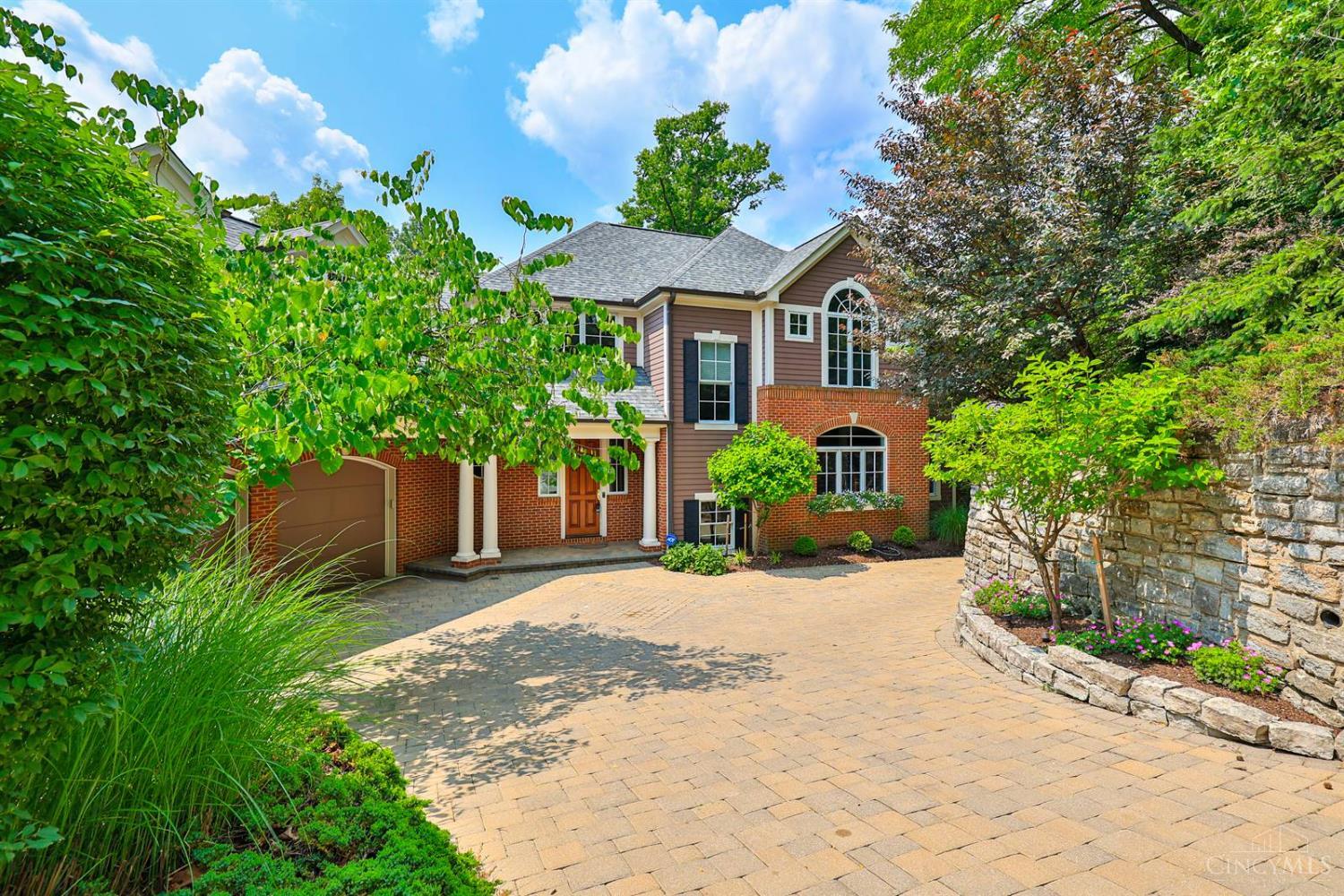 Classic home in a gorgeous setting in Mt. Lookout! Thoughtfully updated with today's finishes. Hardwood floors, large windows, & tons of natural light throughout. Great room features a stone fireplace & custom built ins. An open dining room off the foyer makes entertaining easy. The chef's kitchen features abundant cabinetry, seating bar, & Palladian window over the sink. Dedicated study for work-from-home needs. Expansive primary suite with spa-like bath. Finished lower level with rec/family room with bar & kitchenette adding over 1000sqft of living space. Perfect for gatherings. Enjoy morning coffee on the enclosed porch or relax on the rear deck overlooking mature trees. Adorable storage shed. Solar panels for energy efficiency. EV hookup. 14 speakers (10 on main level & four on the LL). So many updates - Move right in! 5 BR/4.5 Bath. Offers open for 48 hours - No escalation clauses.
