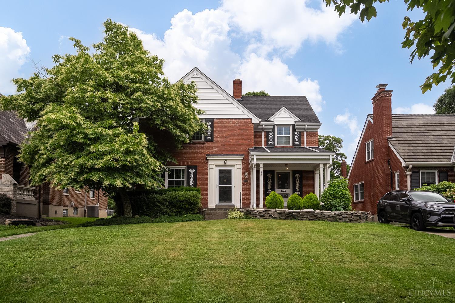 Nestled on a tree-lined street just one block from Oakley Square, this charming two-story home offers the perfect blend of neighborhood warmth and urban convenience. Built by Holscher and Rape, it features graceful archways, a spacious living room, formal dining, a fireplace, built-in shelving, and gleaming hardwood floors. The covered front porch is ideal for relaxing or entertaining. The eat-in kitchen offers solid wood cabinetry, Corian countertops, and a sunny breakfast nook. Upstairs are three spacious bedrooms with ample closet space and a full bath. The finished lower level includes a full bath, new carpet, knotty pine walls, and a decorative fireplacegreat for a family room, office, or guest suite. Enjoy the fenced yard and brick paver patioperfect for outdoor living.