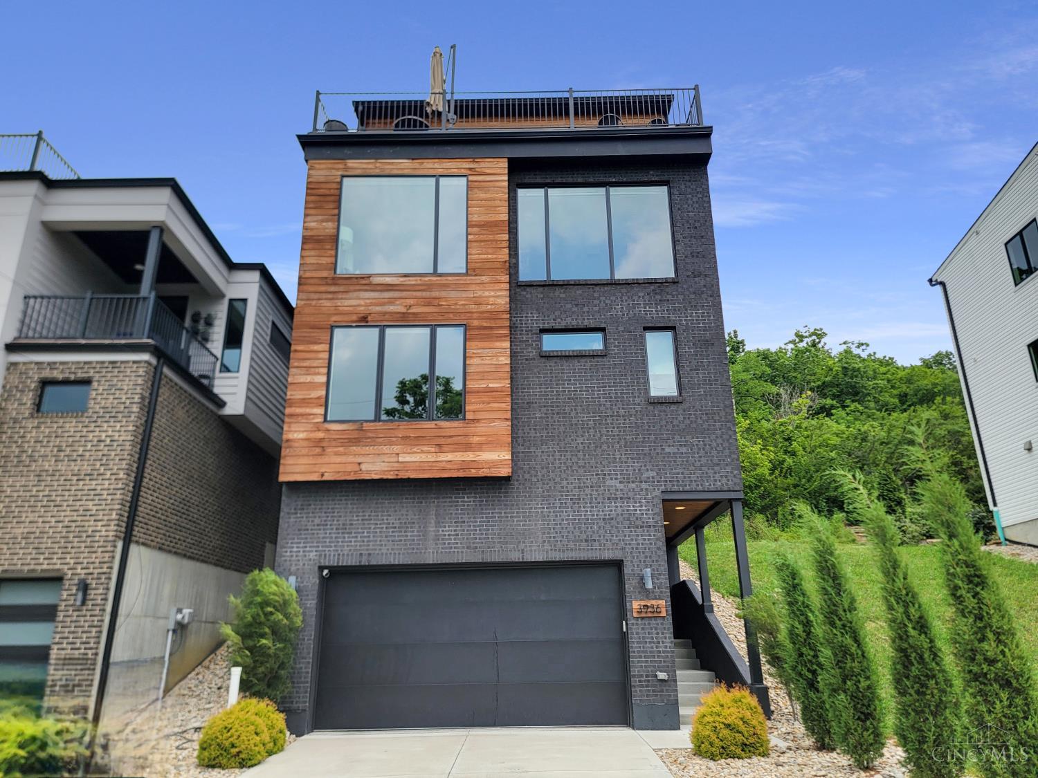 Luxury meets efficiency in this 4-bed, 3 full & 2 half bath LEED Gold-certified home in Columbia Tusculum. With over 3,000 sq ft across 4 stories and a tax abatement through 2038, this home offers unmatched value. The first-floor guest suite doubles as a private office, while an elevator provides easy access to all levels. The third floor features a gourmet kitchen, open-concept living, and soaring ceilings with oversized windows. Outdoor living includes a covered deck with gas/water hookups and a rooftop terrace overlooking green space. EV charger in garage. Minutes to downtown and Lunken Airport.