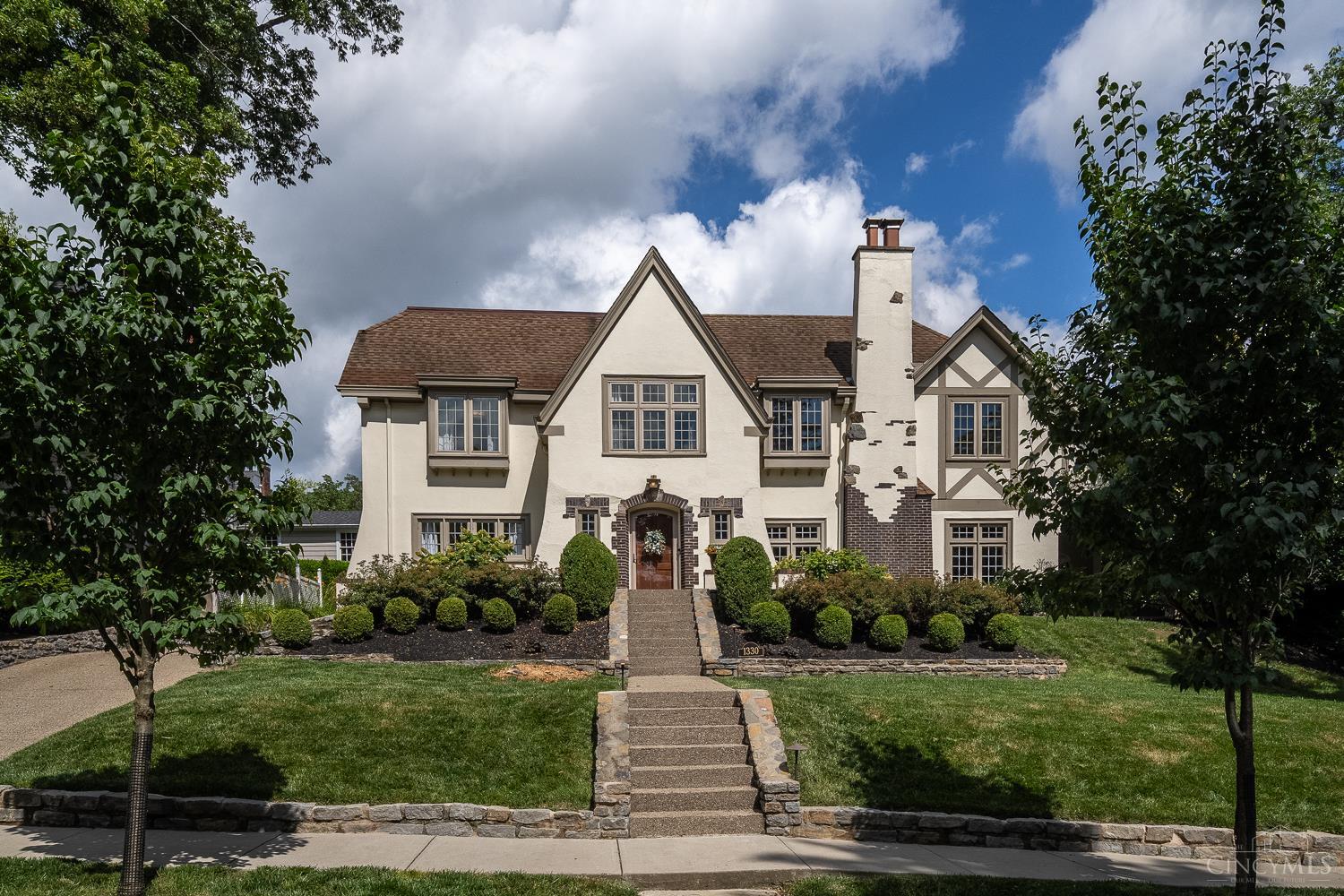 Tucked away on a peaceful cul-de-sac and moments from Ault Park, this classic brick and stucco home is designed for both relaxed living and effortless entertaining. From intimate gatherings to large celebrations, the layout offers grand and casual spaces alike including a stunning formal dining room, welcoming living areas + covered porches for seamless indoor-outdoor living.  With 5 bedrooms, 5.5 baths and a thoughtful floor plan, this home blends timeless character with modern comfort. The primary suite is a true retreat, featuring walk-in and walk-through closets + a private balcony, the perfect spot to unwind at the end of the day. The third-floor suite is ideal for guests, teens, or a nanny.  Downstairs, a finished recreation/playroom provides additional living space, while the manageable yard with a wood playset makes outdoor fun a breeze. Rare opportunity to enjoy classic elegance, everyday comfort + a prime location all in one exceptional home.