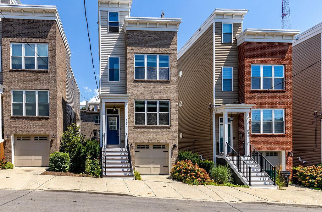 Welcome to 540 Slack St - a modern 3-bedroom, 3.5-bath home with over 2000 sq ft of smartly designed space, just minutes from downtown, OTR, hospitals, and major highways. The open main floor features a spacious living and dining area that flows into a generous kitchen with abundant cabinets, counter space, pantry, and newer appliances. A half bath completes the first floor. Each bedroom includes its own en suite bath, with the primary suite offering a walk-in closet, double vanity, and second-floor laundry nearby. Upstairs, enjoy a private rooftop deck with city views, plus a wet bar and beverage fridge just inside. The lower level includes a third bedroom and full bath, mudroom, and access to the oversized tandem garage with parking for two and extra storage. A small fenced-in yard adds even more flexibility. Don't miss this turnkey opportunity with tax abatement through 2034!
