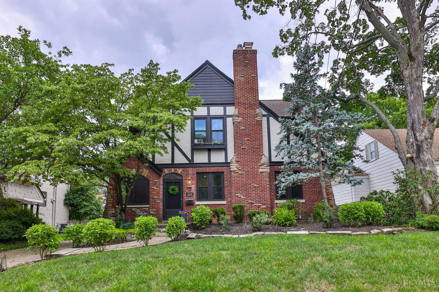 Beautifully restored Mt. Lookout Tudor offers the perfect blend of timeless craftsmanship & modern luxury. Meticulously renovated in the early 2020's this home features refinished original hardwood floors, doors, & hardware. The gourmet kitchen has high-end appliances, stone counters, upper cabinetry (2023/24), & a spacious walk-in pantry. The primary suite is a private retreat with a curbless oversized shower, heated floors, custom walk-in closet, and laundry hookup. Enjoy the Rookwood fireplace, custom blinds including blackout in the primary, & updated windows, electrical, and plumbing. The finished third floor adds flexible living space with bedroom, skylights, mini-split HVAC, and storage. Oversized garage, large basement, and a short walk to Mt. Lookout Square make this home a rare opportunity in an unbeatable location.
