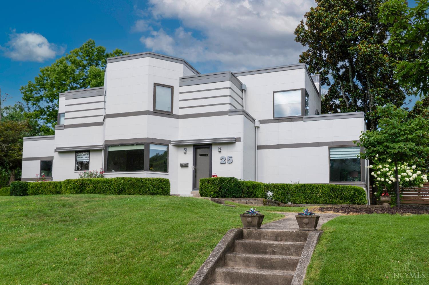 Exceptional Art Deco gem located steps from Ault Park, & once featured in the movie, Milk Money''. This beautifully unique 4-bedroom, 3.5 bath home blends timeless architectural character w modern updates. Gorgeous Tigerwood floors throughout, generous sun-filled rooms. Gourmet kitchen w granite counters, rich wood cabinetry, stainless appliances & wine cooler. Walkout to spacious deck, perfect for outdoor entertaining. Upstairs, find 3 large bedrooms, 2 full baths, & 2 private balconies.  Finished LL with additional bedroom, full bath, & versatile living space, perfect for guests or home office. Attached 2-car garage.