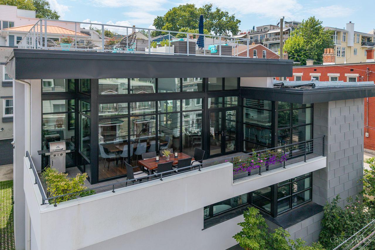 Welcome to The Trillium House - a Mt. Adams masterpiece by Tisley Architects where European-inspired charm meets modern urban living. This 4-bed, 4-bath LEED Platinum home with tax abatement through 2032 blends historic warmth with contemporary, sustainable design. Enter through the gated courtyard with water feature into an airy open floor plan filled with natural light from soaring ceilings and walls of glass. Reclaimed doors/floors, an elevator, multiple outdoor spaces, rooftop deck with river views, and solar panels offer style and convenience. The gourmet kitchen centers the entertaining space, complemented by a two-sided fireplace. The primary suite opens to the courtyard with a spa-like bath. Every bedroom has an ensuite, plus bonus spaces like a workshop, hot tub, and ample storage. Steps to dining and entertainment, The Trillium House is an urban sanctuary.