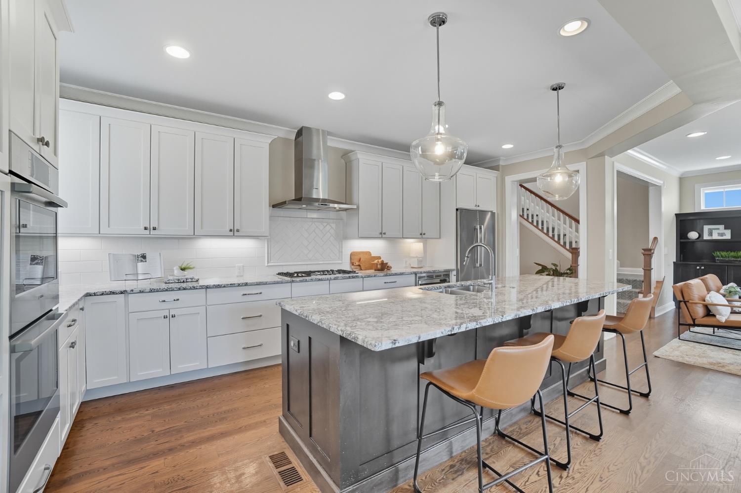 Welcome to 3633 Stettinius Ave. This stunning 5 bedroom, 3.5 bath custom-built home in Home Sweet Hyde Park is Tax abated until 2032! The open-concept first floor features a gourmet kitchen with granite countertops, a spacious island, abundant wood cabinetry, stainless steel appliances, and a large dining area highlighted by a beautiful chandelier. Hardwood floors flow throughout, with sliding doors leading to a back balcony, plus a powder room and mudroom with planning desk. The lower level offers a private bedroom, full bath, wet bar, and walkout to the back patio perfect for guests or entertaining. Upstairs, enjoy second-floor laundry, four bedrooms, and a versatile great room for an office or playroom. The primary suite includes wall-to-wall carpet, walk-in closet, and a luxurious bath with granite double vanity and walk-in shower. All just around the corner from Hyde Park Square's shops and restaurants!