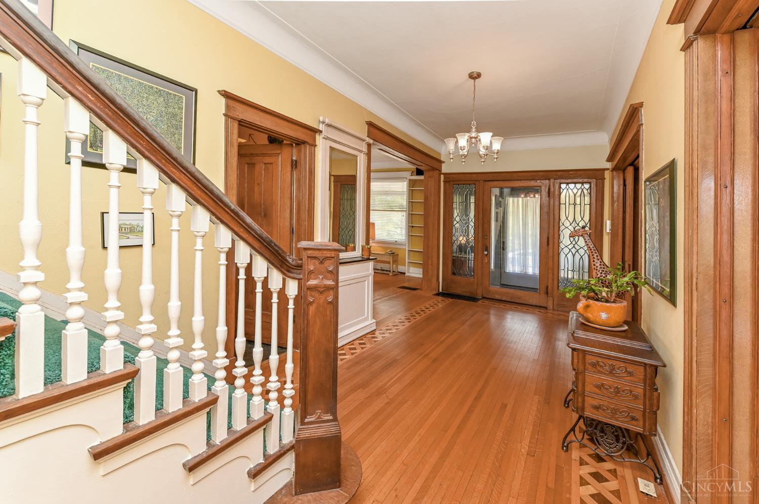 Welcome to 3852 Dakota Ave. in North Avondale. This charming corner-lot home offers a park-like setting with gas lanterns, mature trees, and a full front porch. Step through the beveled glass door into a grand foyer with patterned hardwood floors, high ceilings, and abundant natural light. Spacious living and dining rooms, den with built-ins, and large kitchen with butler's pantry and sliding doors create the perfect blend of historic charm and function. The second floor features four bedrooms with walk-in closets and a full bath; the third floor offers two more bedrooms, a full bath, and storage. Lower level includes workshop, darkroom, laundry, storage, full bath, and new high-efficiency furnace. Enjoy the backyard lily pond, two-car garage, and convenient location near Xavier University.