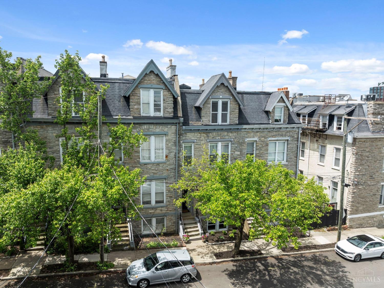 Rare opportunity to own a 3,127 sqft, architecturally unique, 3 story townhome with a FINISHED basement, perched atop the hill in historic Mt. Auburn. This home beautifully combines historic charm with modern updates and boasts, offering plenty of space to live, relax, and entertain comfortably. You'll love the dramatic open central staircase, soaring ceilings, tall baseboards, and hardwood on the main level. All 4 bedrooms are generously sized with ample closet space, 3 of 4 featuring en-suite baths. Additional highlights include a convenient second floor laundry and a finished basement with a wet bar, perfect for entertaining. Enjoy easy access to Hopkins Park, just outside your front door, and close proximity to Mt. Adams, downtown Cincinnati, and the University of Cincinnati. Option to lease a detached, 1 car garage for quarterly lease fee of $120 ($480/year).