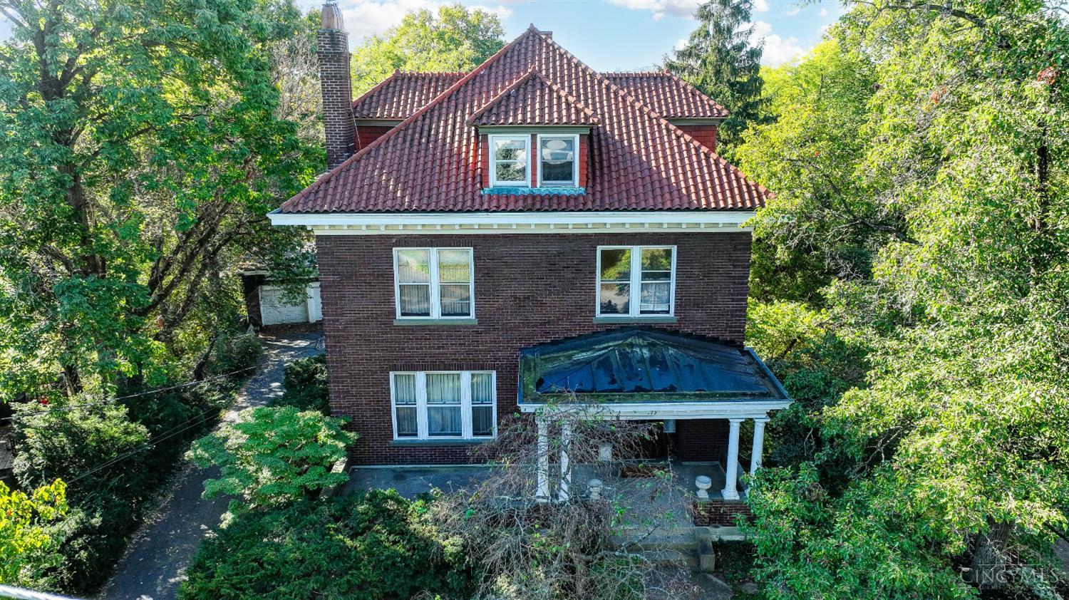 This stately Gaslight Clifton home with an S-tile terracotta roof is situated on over an acre with an oversized detached garage and a large studio ADU tucked away amidst the gardens in the back. A wide front porch welcomes your guest and an airy entryway welcomes them in with high ceilings and intricate stained glass at the top of the original carved banister. An abundance of historical details remain - hardwood floors, generous formal living & dining with double pocket doors & bay window, sunny breakfast room with butler's pantry, and gourmet kitchen opening onto the covered back porch with convenient back stairwell and powder room nestled into the half floor. Upstairs the primary bedrooms, an adjoining bookshelf-lined study & 2 more comfortable bedrooms are served by two hall baths. On the 3rd floor two more bedrooms are ready to appoint as you see fit - office, guest rooms, family room? You decide! In the unfinished lower level you'll find laundry, a full bath, workshop & more.