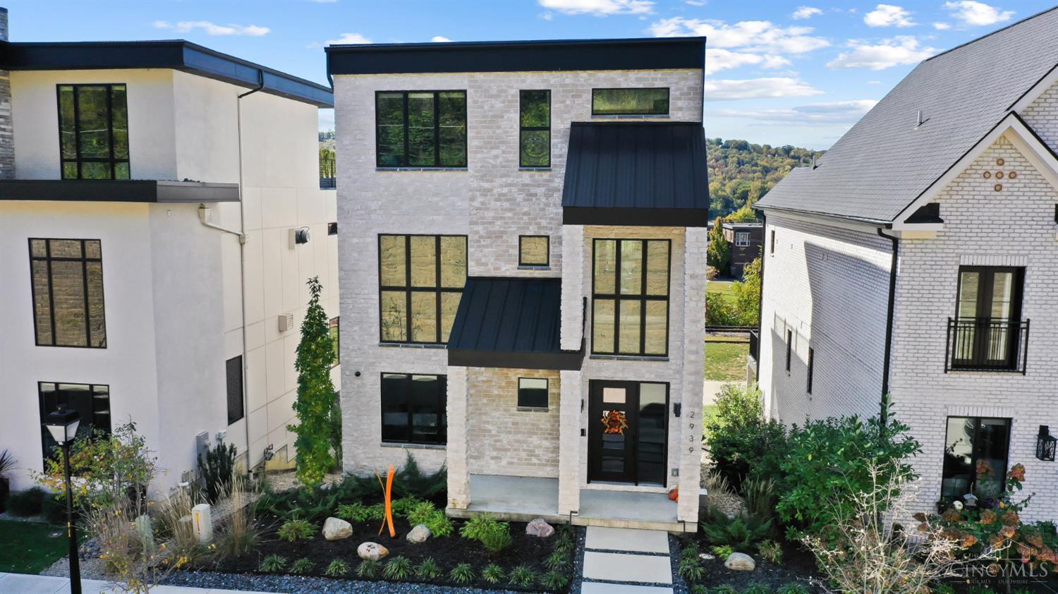 Experience modern luxury living in Cincinnati's East End with this stunning 2022-built home offering breathtaking views of the Ohio River. This 4-bedroom, 4.5-bath contemporary residence features light-filled open spaces, sleek finishes, and exceptional attention to detail throughout. The designer kitchen includes premium appliances, custom cabinetry, and an oversized island ideal for entertaining. Expansive windows flood the home with natural light and frame serene river views. Enjoy year-round outdoor living on a two-tiered deck with built-in heaters, a gas grill hook-up, and space for dining or relaxation. A state-of-the-art audio-video smart home system and personal elevator. Just 10 minutes from downtown and steps from local restaurants and coffee shops, this home perfectly blends modern luxury with urban convenience and riverfront tranquility.