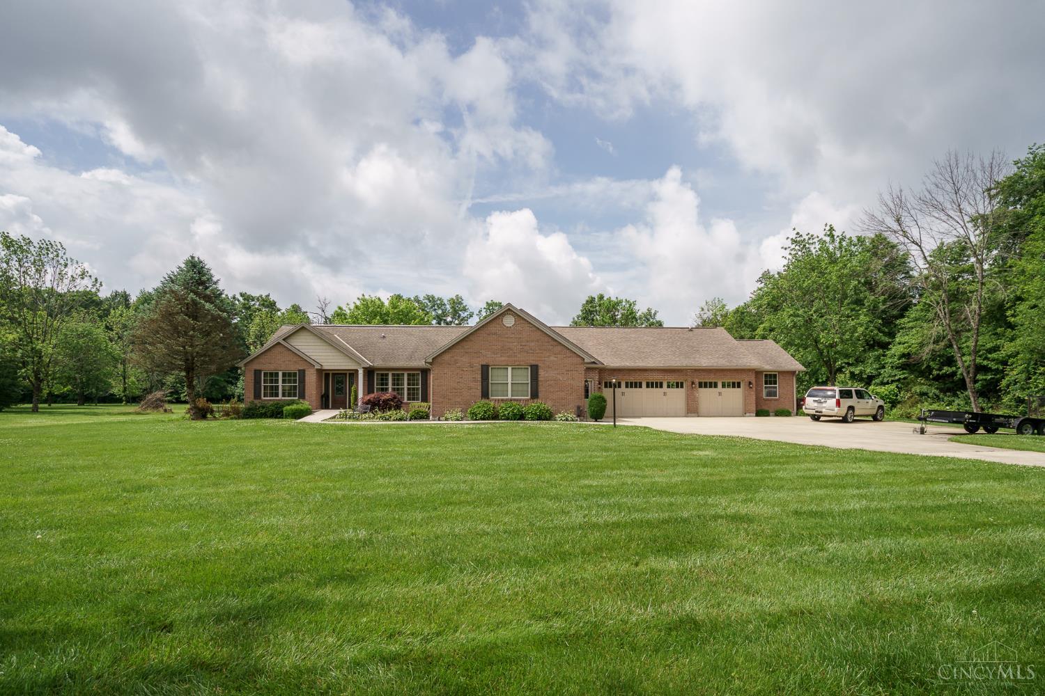 Custom-built ranch on a private, flat 5-acre lot just minutes from historic downtown Williamsburg. This spacious home features 5 bedrooms, 4.5 baths, an open floor plan, and a fully finished lower level perfect for entertaining or multi-generational living. The great room showcases soaring vaulted ceilings with exposed beams and abundant natural light. The Kitchen offers custom wood cabinetry, granite countertops, stainless steel appliances, and a counter bar, flowing into a four-season room overlooking the patio and private backyard. The finished lower level includes two ensuite bedrooms, a full kitchen, laundry room, study, and large family room. The attached 5-car garage features a dog kennel and exercise room. Enjoy peaceful country living with convenient access to SR 32 and I-275. Please note the seller is selling this property in As-Is condition (Some mechanical systems do not operate).
