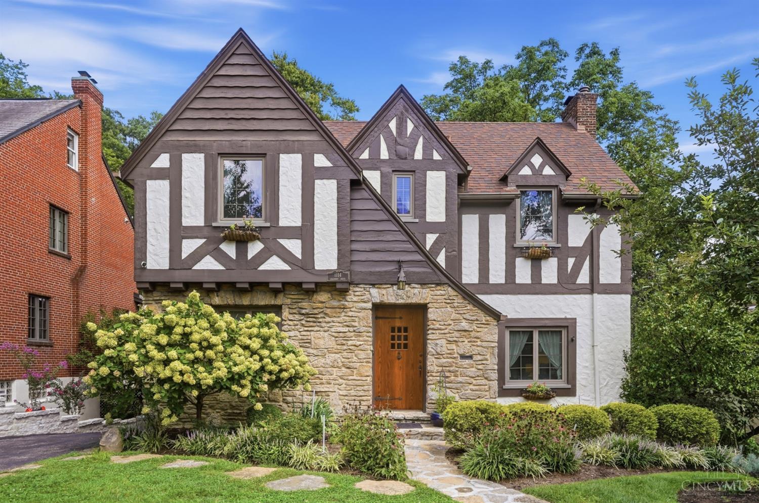 Welcome to 1114 Salisbury Drive, a beautifully maintained Tudor-style home on a tree-lined cul-de-sac in Mt. Lookout. Combining timeless character with modern updates, the home features a stunning remodeled kitchen. The first floor includes formal dining and living spaces, a classic Rookwood fireplace, remodeled powder room, and beautifully renovated sunroom with Rookwood tile flooring, new window, and accordion doors leading to the expansive deck. Upstairs, three spacious bedrooms include a private guest suite with remodeled full bath, while the generous primary bedroom connects to a Jack-and-Jill bath shared with an oversized additional bedroom. A partially finished lower level offers recreation space and storage, complemented by an attached two-car garage. Professionally landscaped grounds, a freshly painted deck, and a deep wooded backyard provide a peaceful setting for relaxing or entertaining. Ideally located near Kilgour Elementary, Ault Park, and Mt. Lookout Square.