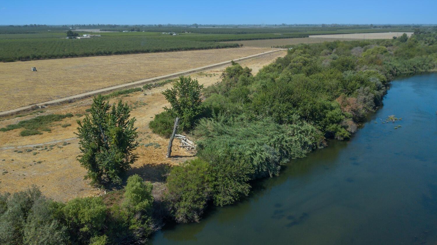 This is a dream location to build your riverfront estate on the Kings River. Properties with this much river frontage are extremely rare and hardly ever come to market. It is located at the end of a dead-end road for ultimate privacy. A district canal runs through the property and the surrounding properties are planted to stone fruit and almonds. Be sure to check out the aerial video.