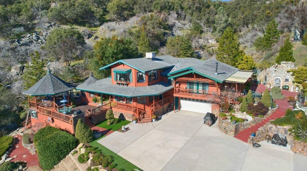 Gorgeous mountain views surrounding this stunning custom storybook home sitting on 40+/- private acres is waiting for the right person to experience this beauty! The center of the home is open to the 3rd floor with beautiful wood interior throughout! Built in 1987 with 3117+/- sq. ft. 3 bathrooms and a bonus room. 1 level is a large bar with taps, counter bar, chairs and all of the items that go with it! Large kitchen is open to the living room with large island, breakfast bar and nook along with a formal dining area. Lots of storage space! The seasonal creek is absolutely amazing when it is flowing with bridges and walkways below, lots of rock outcroppings, Pines and Oaks to enjoy nature! From the time you pass through the gated entrance, 