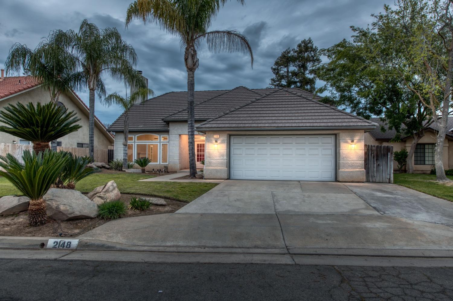 This single story home falls within the boundaries of Clovis Unified, specifically Clovis North High School. This residence has 3 bedrooms, 2 bathrooms and a swimming pool. The front yard has great curb appeal with the palm trees and sagos. The main living space is a very open concept blending together the kitchen, formal dining area and family room. The combination of the fireplace and lofty ceilings creates an enhanced sense of spaciousness and comfort. The kitchen features a gas stove, pantry and room for bar stool seating at the island. The Anlin windows, whole house fan and newer HVAC unit are a few amenities that are helpful for energy efficiency. The master suite is spacious and was added onto, providing a second master closet / office or fitness area. The backyard revolves around the swimming pool, and with the rising Fresno temperatures, it's going to be a hot commodity. The backyard is low maintenance, has a covered patio and has room for you to add your own putting green, lounge area or outdoor kitchen!