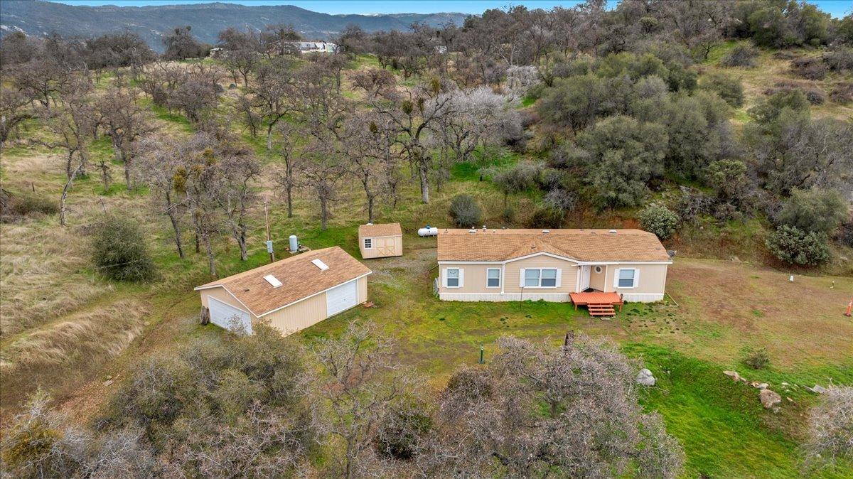 37806 Boxalder Lane Yokuts Valley, California Welcome to Boxalder where the breathtaking views of the valley below offers a stunning backdrop to your daily life. Escape to this charming 3-bedroom, 2-bathroom foothill home, where modern updates and serene living come together perfectly. Enjoy a cooler, cleaner lifestyle (10 degrees below the valley) while being surrounded by the peaceful beauty of nature, with deer and other wildlife often in view. The kitchen features a newer stove, microwave, sink, and fridge, making meal prep a breeze, and the spacious master bedroom offers a custom closet organizer for added convenience. The large detached garage/shop (704 sq ft) is a true bonus, complete with a workbench and ample shelving for all your projects and storage needs. With the quiet surroundings and panoramic vistas and only 45 minutes from town or Kings Canyon National Park, this home is the ideal retreat for those seeking peace, privacy, and modern comforts.