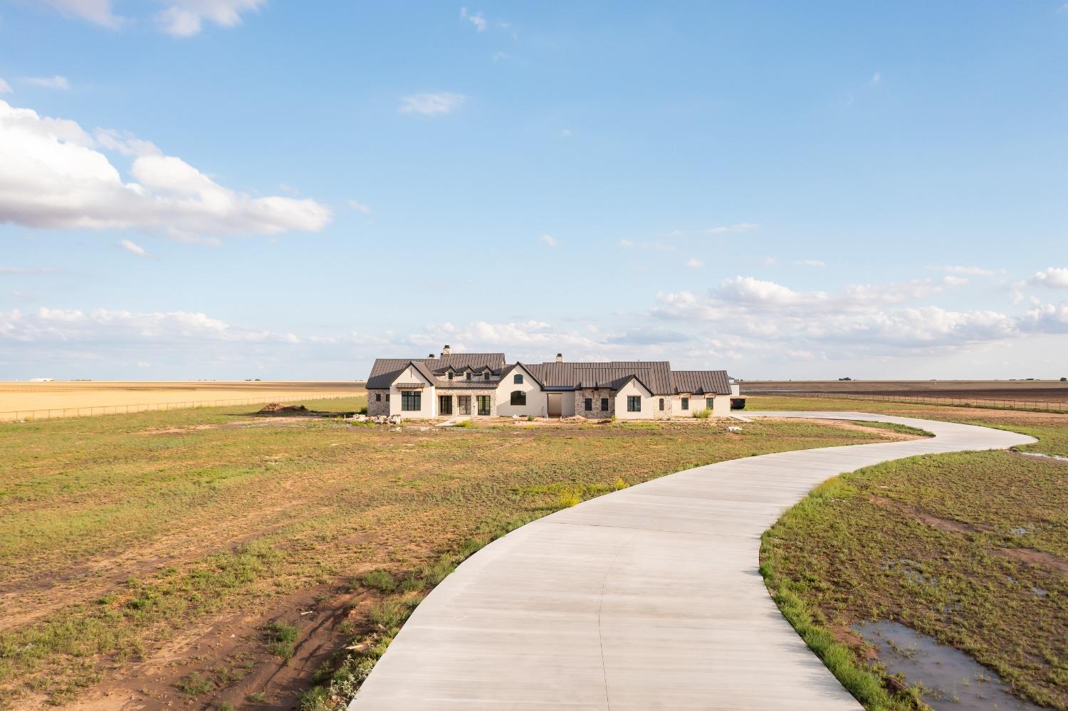 This stunning home built by Apex Homes is modern luxury living situated on 15 acres with a 15,000 SF barn, pipe fencing and a backdrop of grassland, offering the ultimate oasis. You'll find a magazine worthy design perfectly planned by HHC Living. The New Traditional Style is meant to be colorful and cozy, classic and contemporary, timely and timeless. An open concept plan is the heart of this home with a gourmet kitchen featuring high end appliances, ample space to entertain while the main living area is spacious and features large windows that provide picturesque views of the surrounding landscape. A Game Room inspired by the Drover Hotel is perfect for hosting. The Primary suite boasts a marble fireplace, separate closets and private water closets. The home provides a study and 3 additional generously sized bedrooms, each with an en-suite bath. With high end finishes including custom mill work, marble countertops, wood floors, and marble tile, you'll want to see this today!