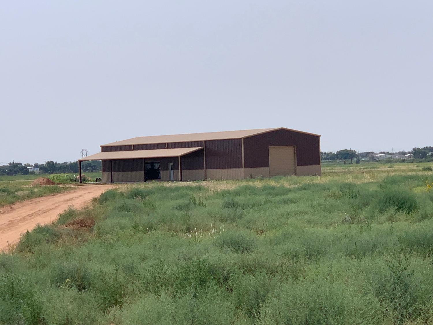 Great 40 X 100 Bandominium on 10 Acres In Shallowater. Living area is 70 x 20 with a 70 x 10 porch.  2nd bedroom is a loft could easily be made into 2 rooms.  Large master with a great shower.  Complete with stalls, pens and a chicken coop.  Barn is insulated with 2-20 foot doors