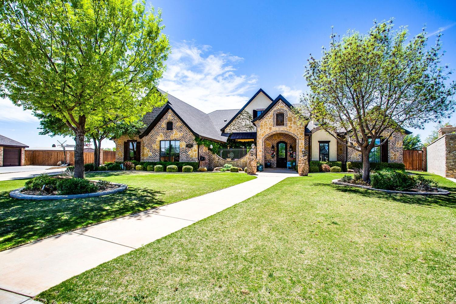 Welcome to this exquisite French Country home with European style built by Dan Wilson! Curb appeal 10/10, brick, stone, and stucco greets you upon arrival, along with a secluded front porch that is enclosed with custom iron work and gate with water feature and french doors going into the kitchen.  Step inside to brick entryway to the custom stained cabinetry throughout. The master suite boasts an office overlooking the pristine pool, an oversized closet, and a uniquely designed double-barrel ceiling. The living space offers cathedral ceilings soaring to 22 feet adorned with rustic beams, while the dining area features a captivating dome ceiling. The game room offers cathedral ceilings, rustic beams, a wet bar that's perfect for entertaining. Boutique lighting throughout, Christmas closet with built-ins. The gourmet kitchen features double ovens, an oversized pantry with a custom painted door from Peru. Secluded guest quarters with a private bathroo